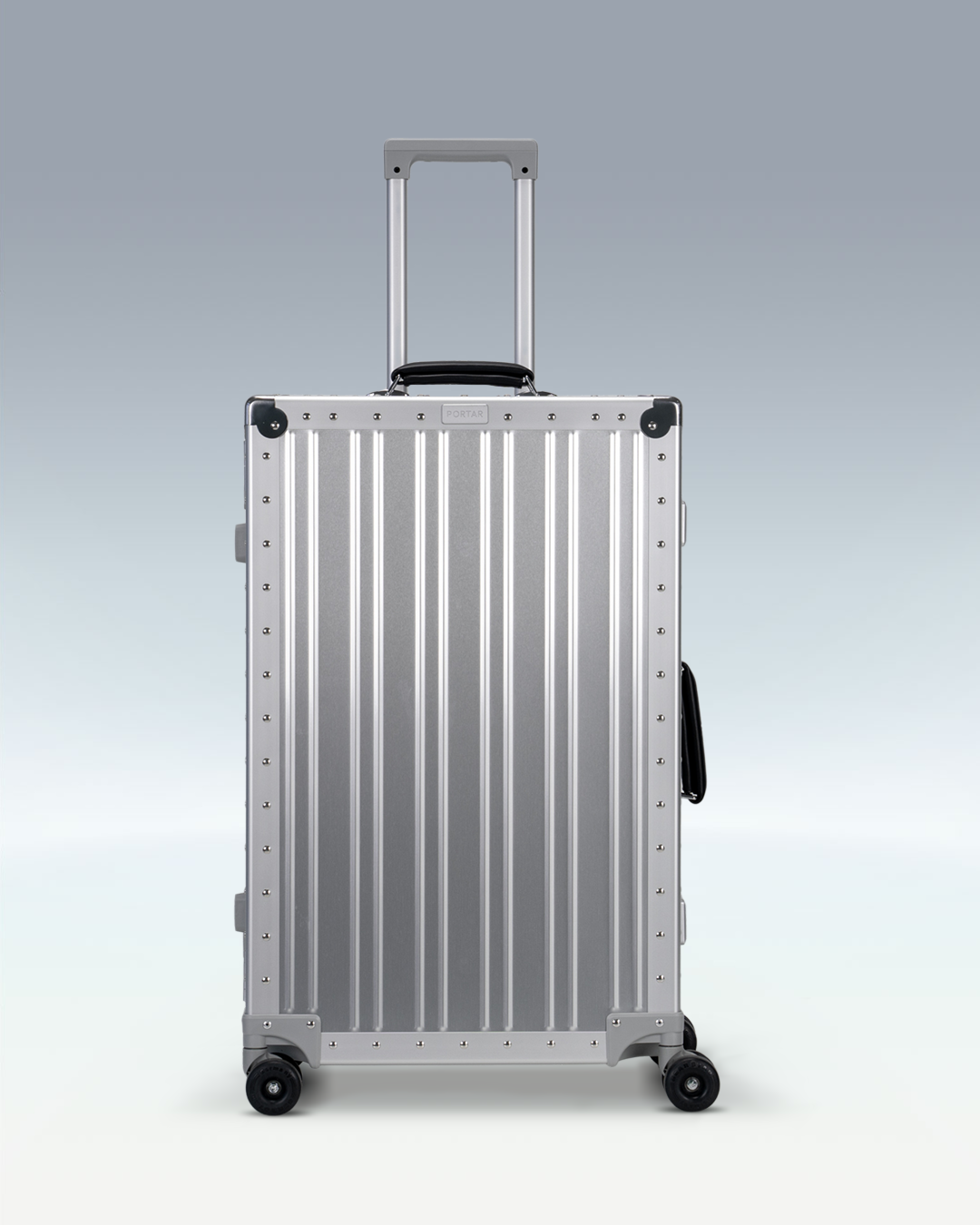 Portar Lucent aluminum checked luggage in Lunar Silver, front view with the telescoping handle extended