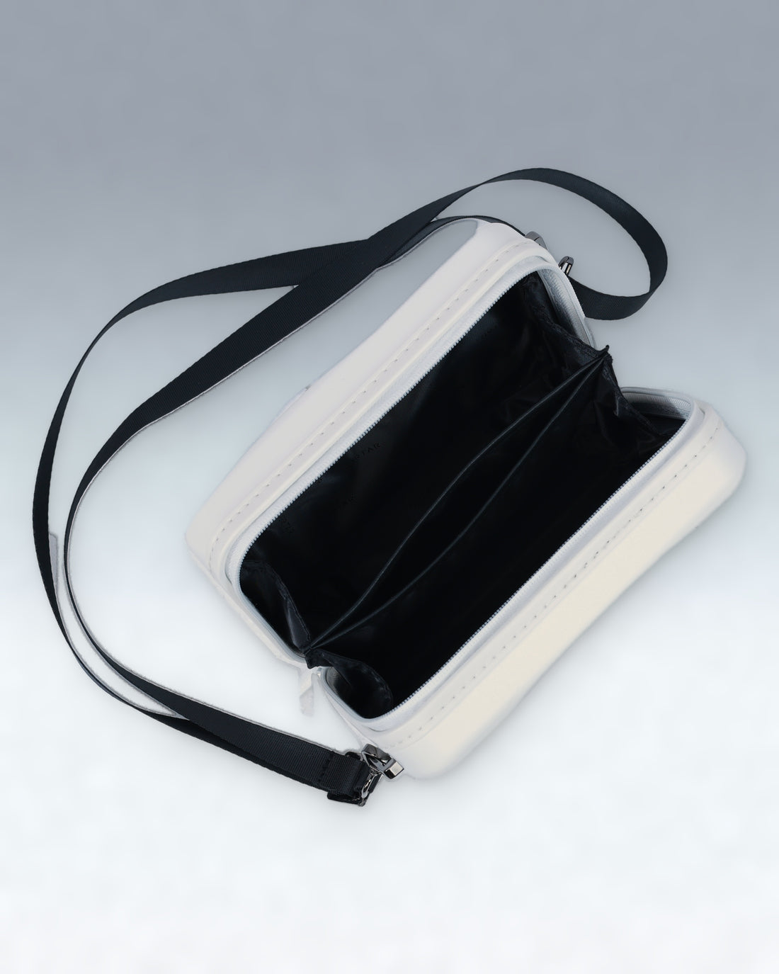 A Cloud Dancer White Portar rectangular crossbody bag with a black interior and a black shoulder strap, shown open on a light gray background.