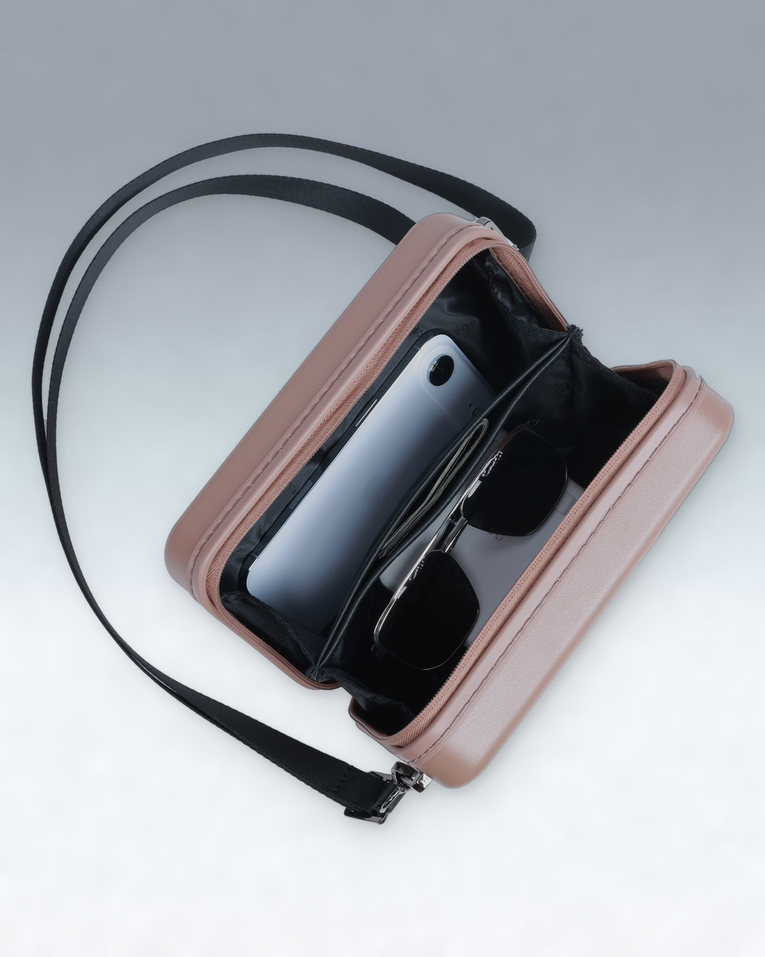 A Mocha Mousse Brown Portar crossbody phone bag with a black strap, shown open to reveal a black interior holding a smartphone and sunglasses, set against a light gray gradient background.