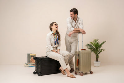 Women sitting next to a Lucent Aluminum Jet Black Suitcase