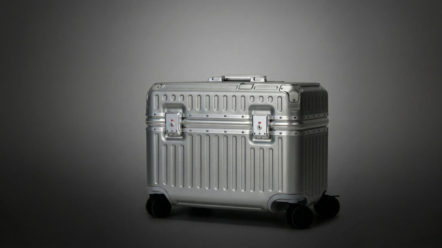 Silver suitcase with wheels on a gray background