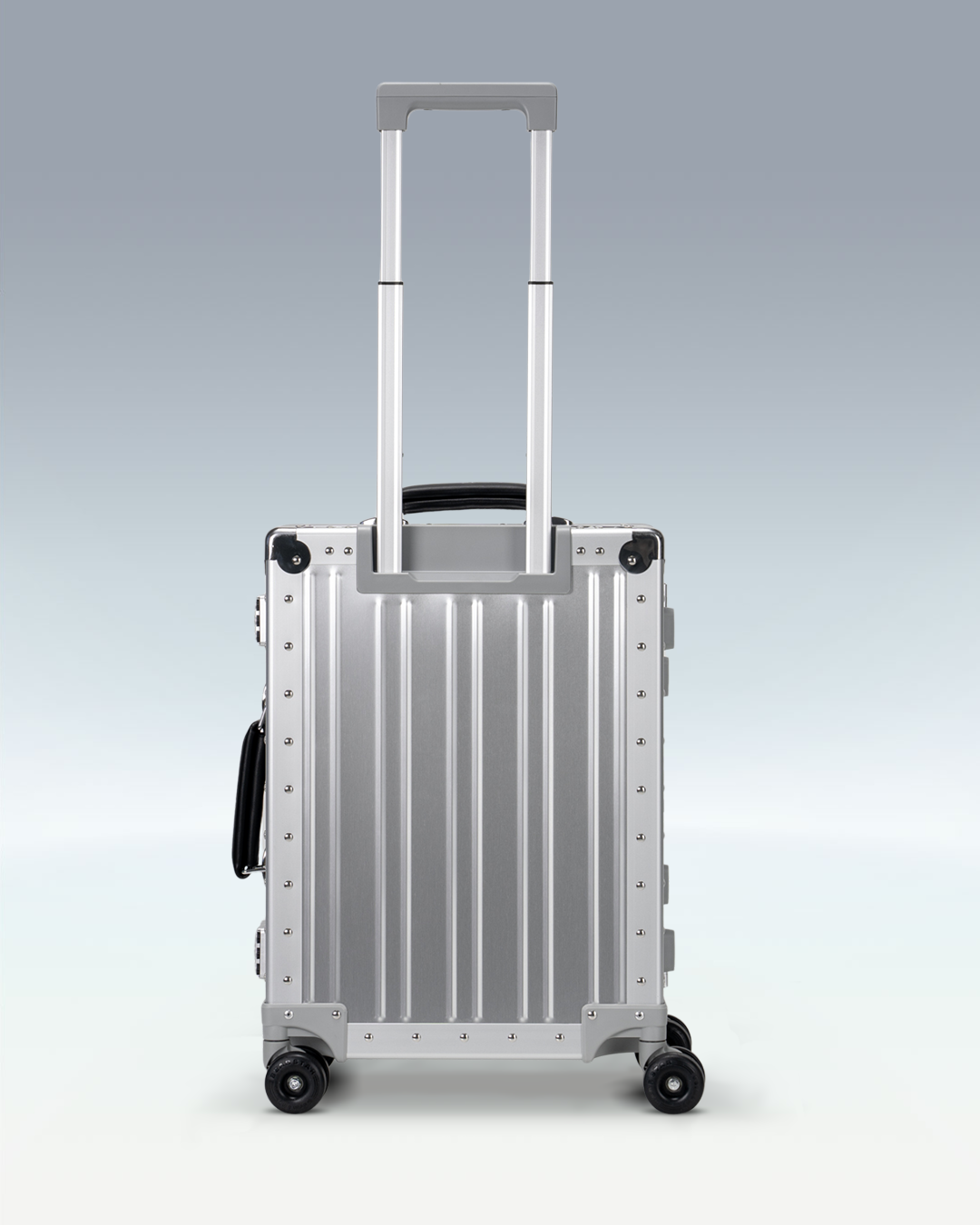 Portar Lucent aluminum carry-on luggage in Lunar Silver, back view with the telescoping handle extended