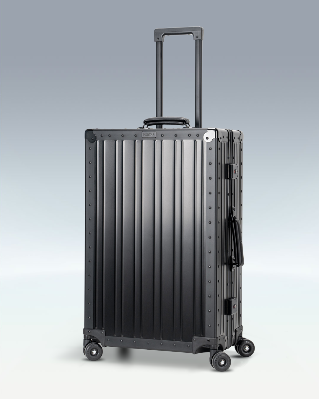 Portar Lucent aluminum checked luggage in Jet Black, three-quarter view with the telescoping handle extended