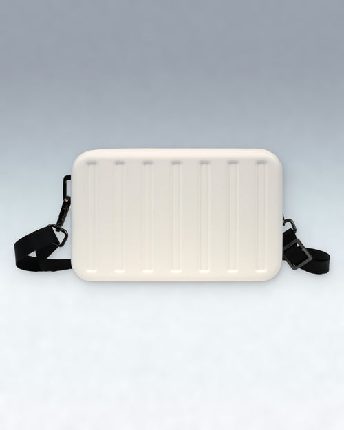 A Cloud Dancer White Portar rectangular crossbody bag with a ribbed front panel and a black adjustable strap, shown against a light gray gradient background.