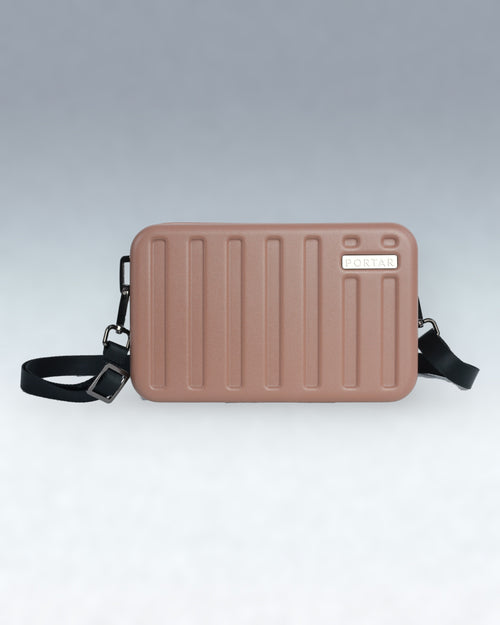 A rectangular, hard-shell crossbody bag in a dusty rose or mauve color, featuring vertical ribbed detailing on the front, a small silver-tone brand plaque reading 'PORTAR', and an adjustable black shoulder strap, shown against a neutral gray gradient background.