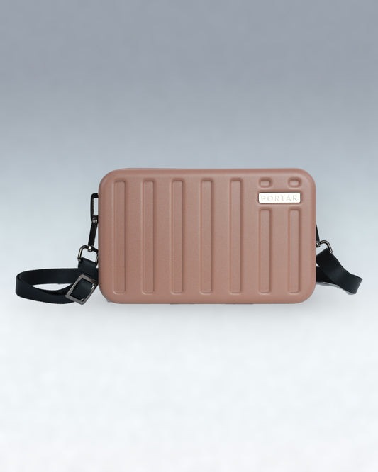 A rectangular, hard-shell crossbody bag in a dusty rose or mauve color, featuring vertical ribbed detailing on the front, a small silver-tone brand plaque reading 'PORTAR', and an adjustable black shoulder strap, shown against a neutral gray gradient background.