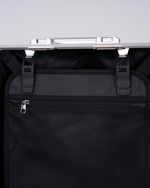 Portar polycarbonate shell with aluminum EdgeFrame suitcase interior details with black interior on one side of the suitcase on a light gray background